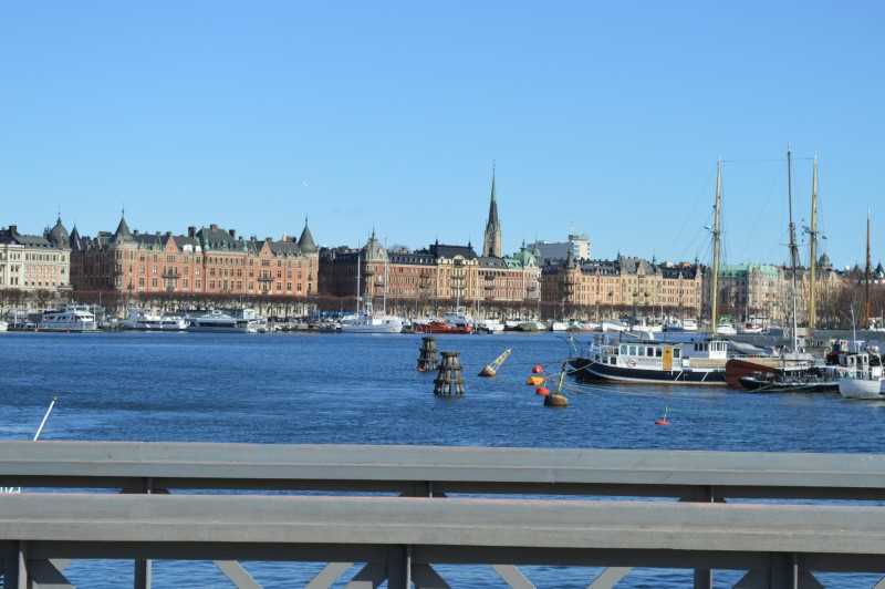  Utsikt över en vattenkanal i Stockholm med båtar förtöjda längs kajen.